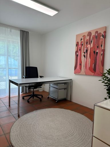 Helles Büro mit Schreibtisch, schwarzem Stuhl, Pflanzen und modernem Kunstwerk an der Wand.
