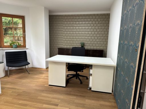 Helles Büro mit einem Schreibtisch, einem Stuhl und einer dekorativen Wand.