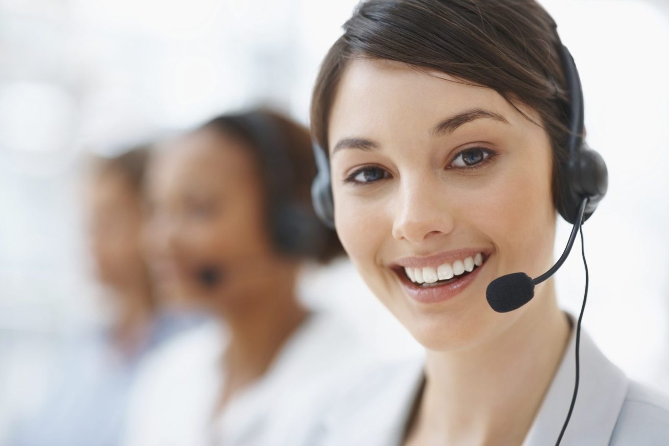Lächelnde Frau mit Headset, die in einem Callcenter arbeitet.